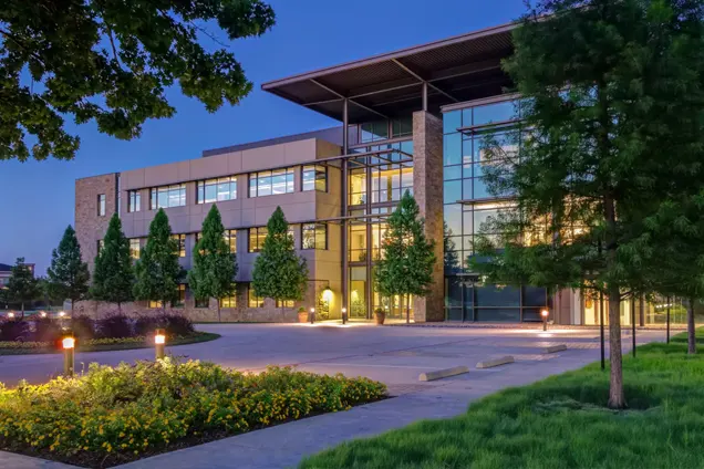 Commercial property landscape maintenance with modern office building and landscaped grounds.